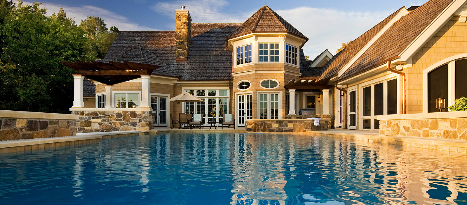 Luxurious swimming pool & hot tub with stone walls